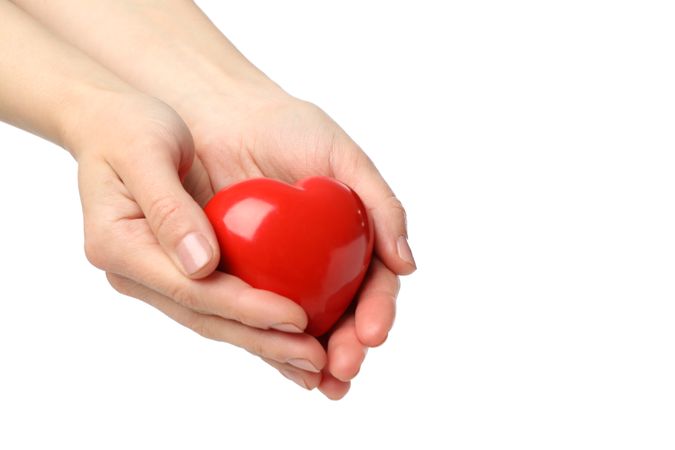 Female hands hold heart, isolated on plain background