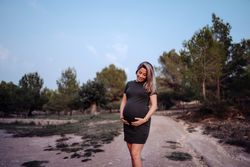Charming pregnant woman standing on walkway in park
