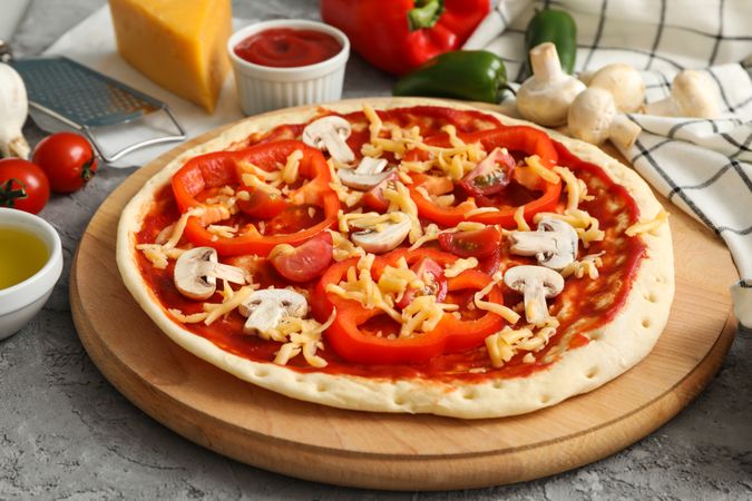 Concept for cooking pizza with ingredients on gray table