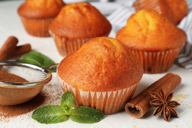 Composition with muffins and cinnamon on light background