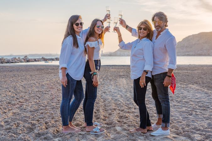 Happy family drinking wine on beach