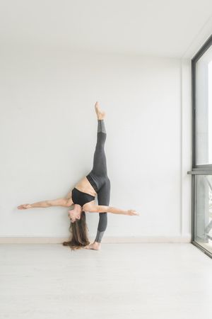Flexible female training upside down in studio