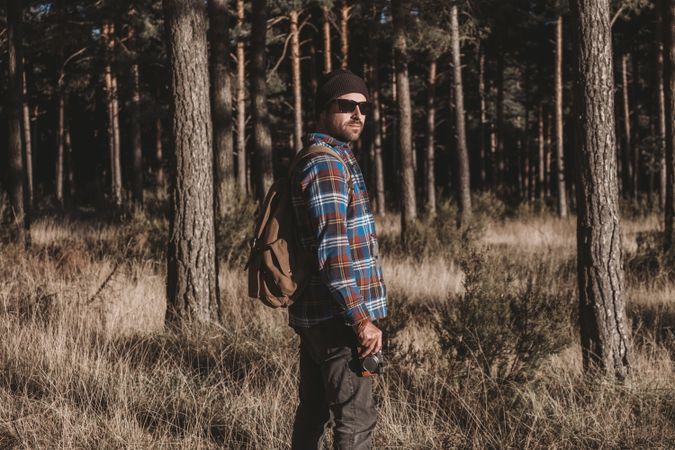 Confident tourist walking along autumn forest
