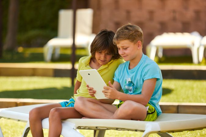 Boys using tablet in garden