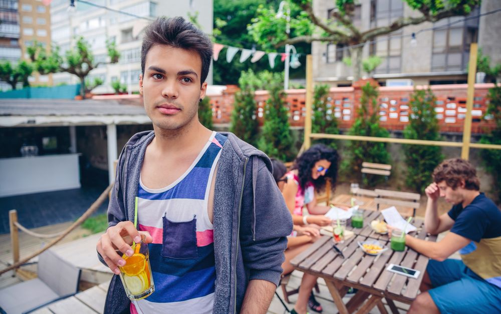 Man standing up from table with empty drink