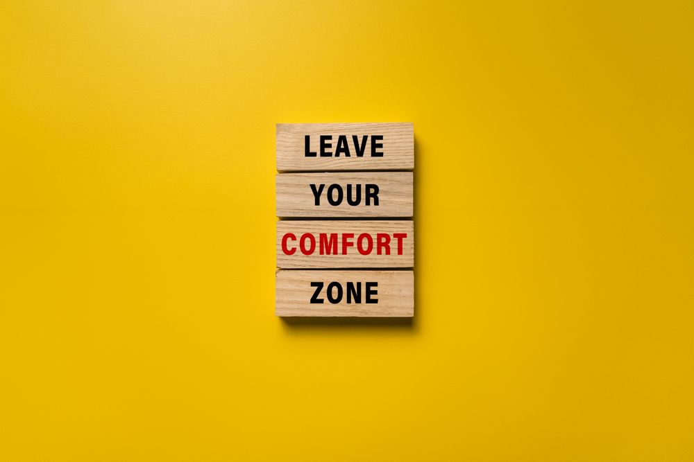 leave your comfort zone words on wooden blocks isolated on yellow background