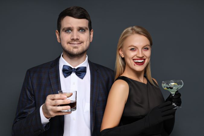 A woman and a man in Halloween costumes on a dark background