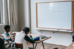 Back view of a boy and girl sitting in classroom