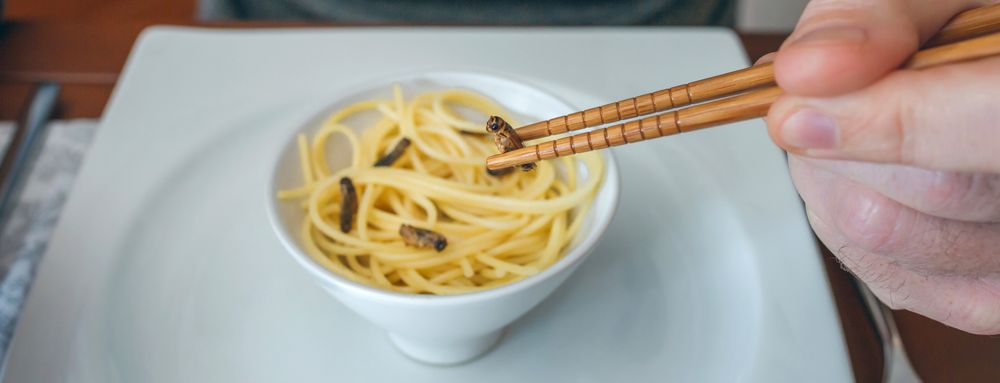 Man eating spaghetti and crickets