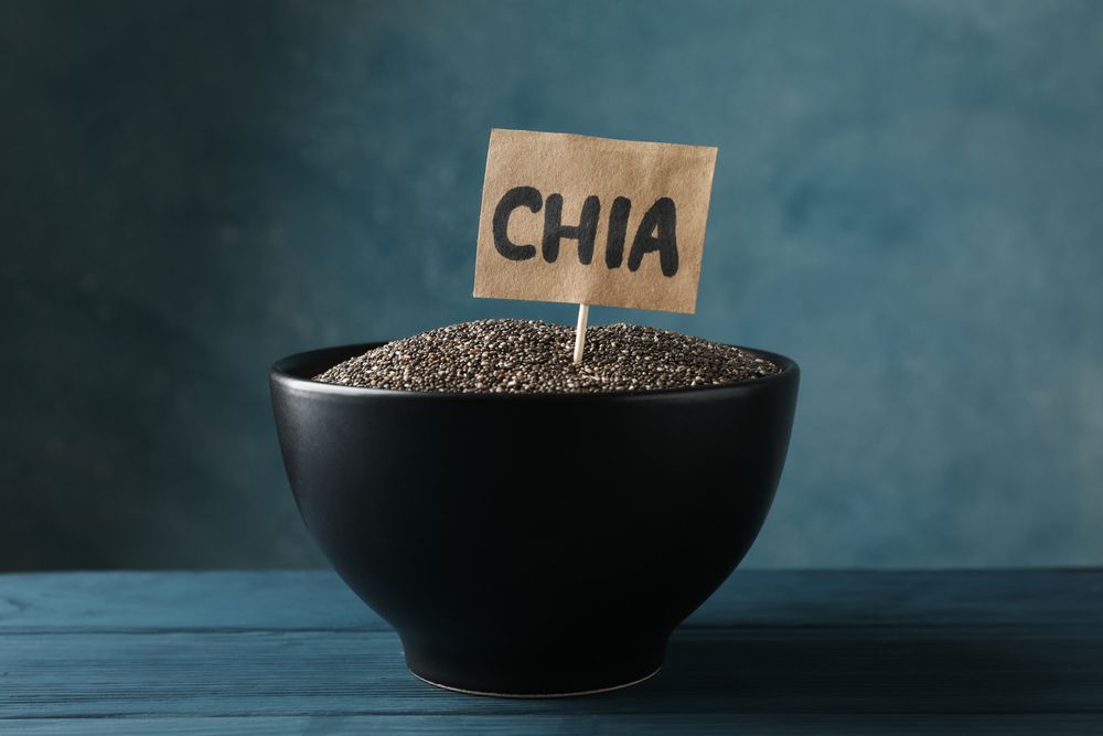 bowl and word Chia on wooden background, copy space