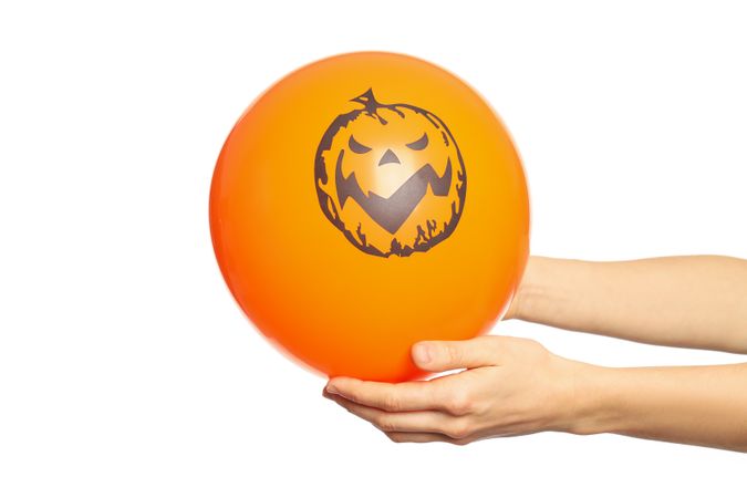 Female hands hold halloween balloon, isolated on blank background