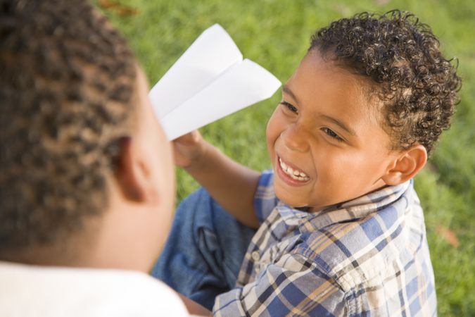 Smiling Father and Son Playing with Paper Airplanes