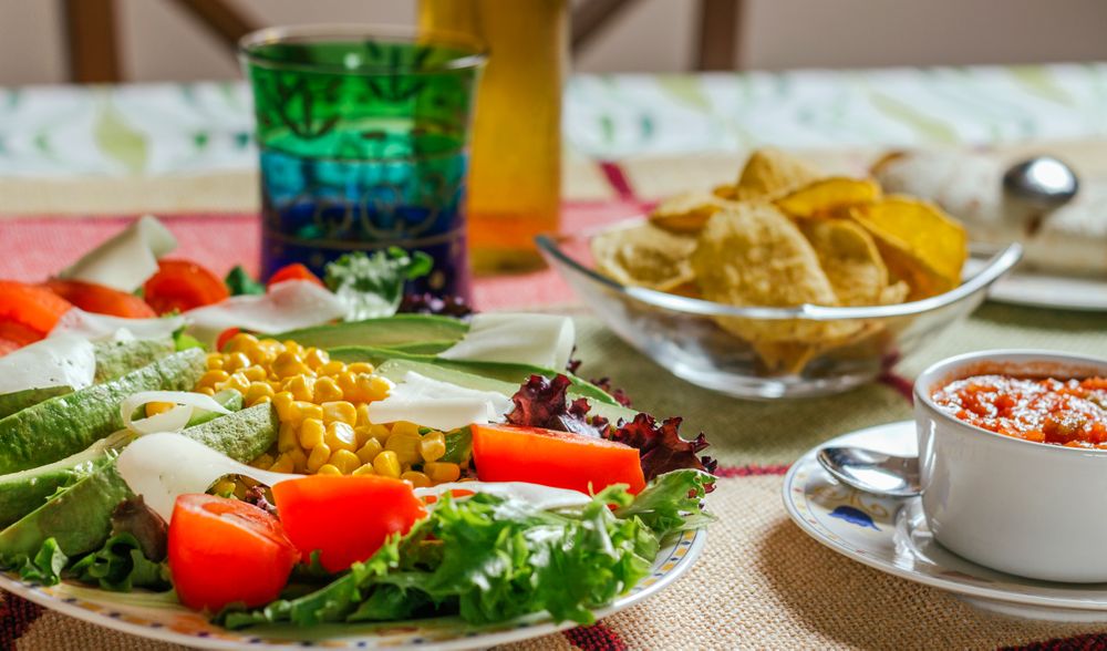 Traditional mexican food with a plate of fresh salad, nachos and