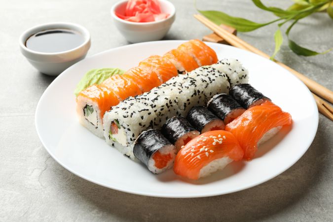 Plate with sushi rolls on gray background. Japanese food
