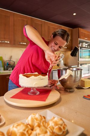 Smiling woman making dessert at home