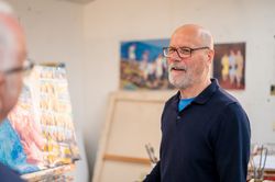 Male artist chatting with friend in studio