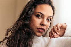 young woman sitting on sofa near window with warm light