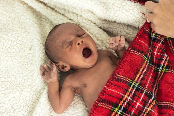 Newborn baby on soft tartan blanket