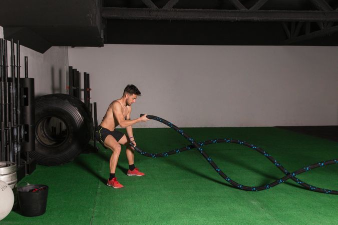 Man training with ropes in gym
