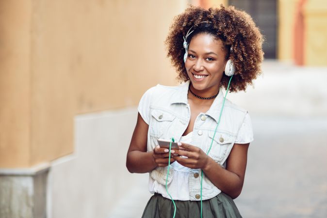 Happy woman smiling at camera while wearing headphones