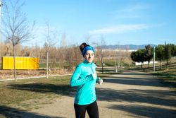 Woman jogging in park on cool autumn day