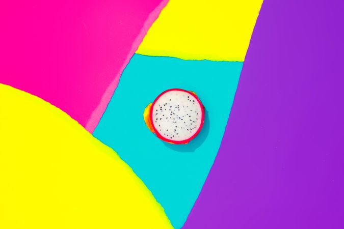 Draganfruit on pattern of ripped paper in vivid colors