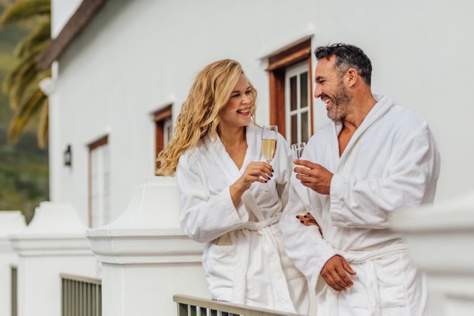 Beautiful couple in bathrobe having wine