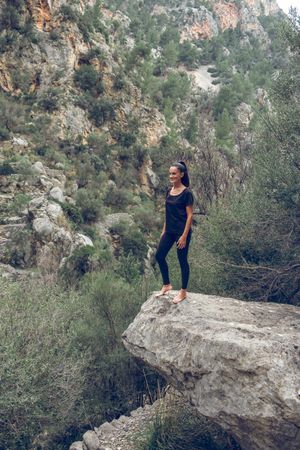 Woman standing on rock near mountains