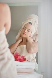 Woman in towel relaxing at mirror