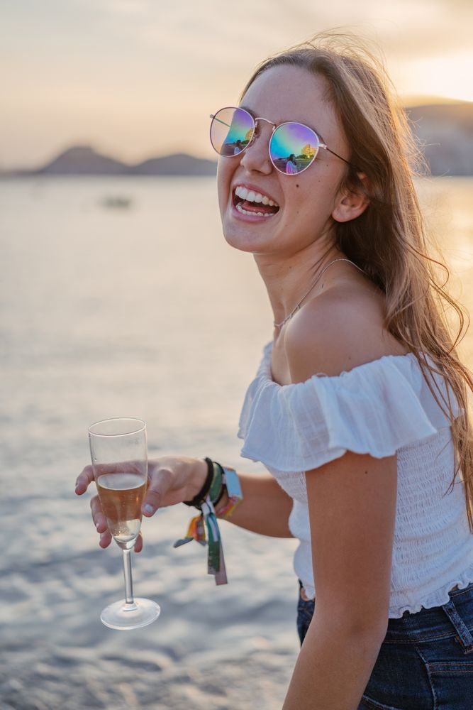 Young woman enjoying wine near sea