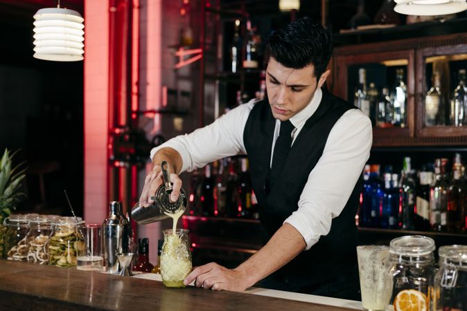 Barman working mixing pouring drink in a glass