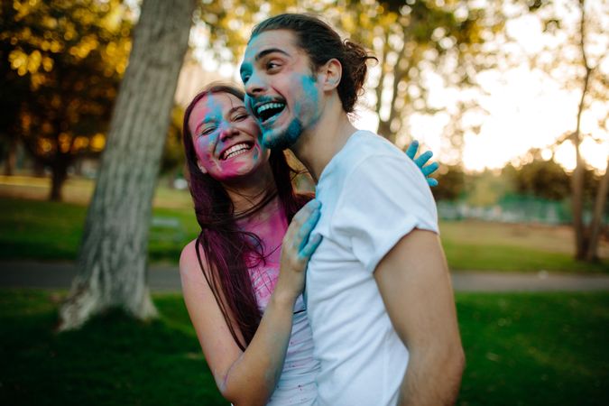 Smiling young couple with colored powder smeared on their faces
