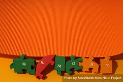 Orange background with puzzle pieces spelling out the word “Memory” 0LGKgb