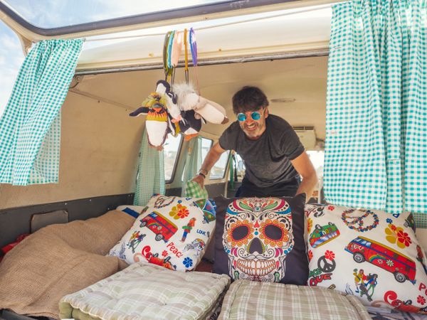 Man straightening colorful pillows in car trailer
