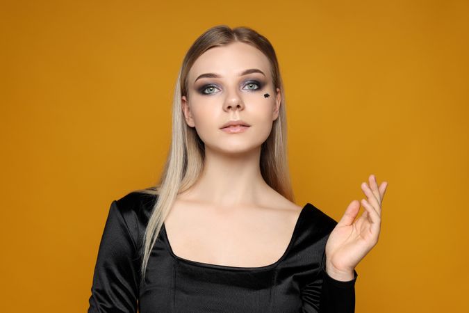 Concept of Halloween, young woman on yellow background