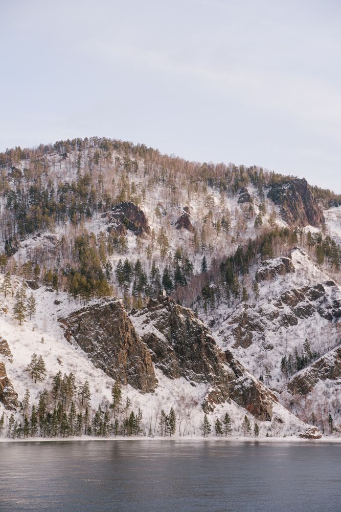 Wide Siberian river and snowy mountains