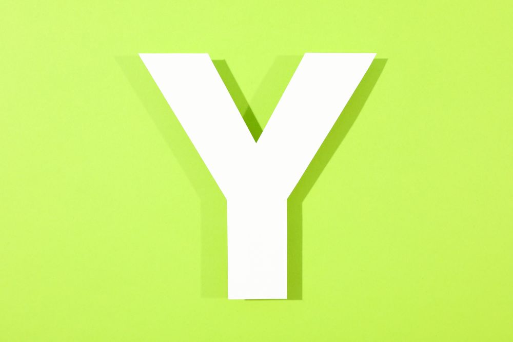 Paper letter Y on color background, space for text