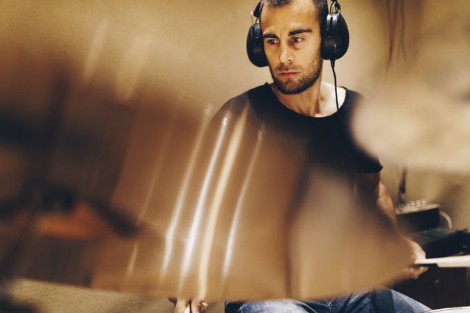 Man with headphones playing on drums