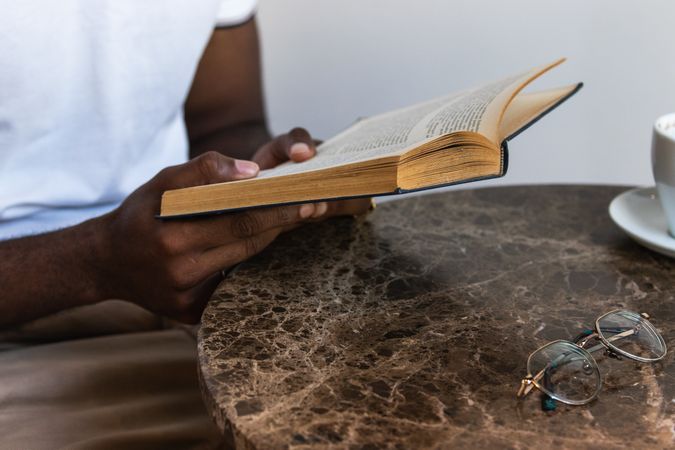 Black male reading book in cafeteria