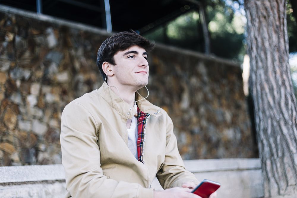 Man sitting outdoors with mobile phone