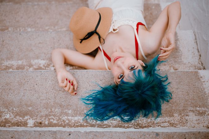 Sensual woman in sundress lying on pier stairs