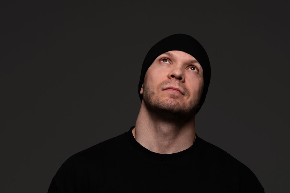 Man in beanie and sweatshirt looking up