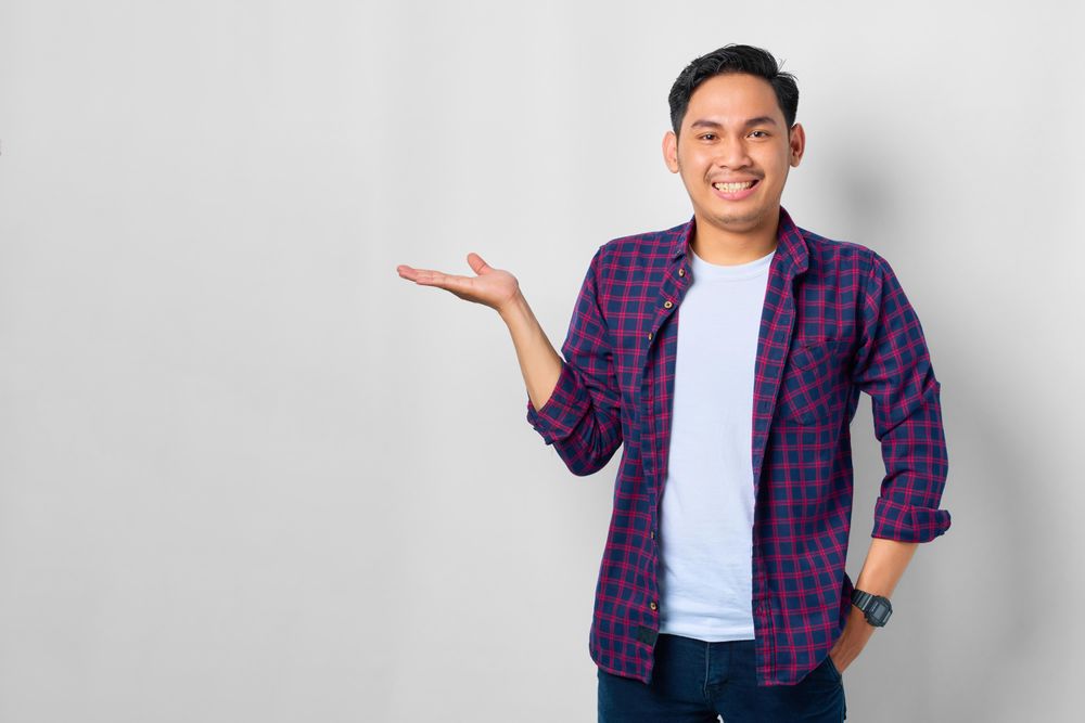Asian male in grey studio presenting something