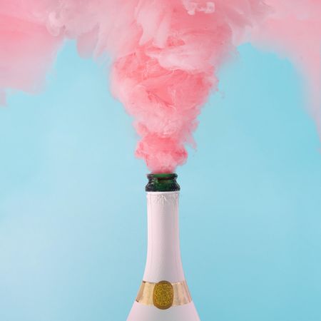 Pastel pink champagne explosion on blue background