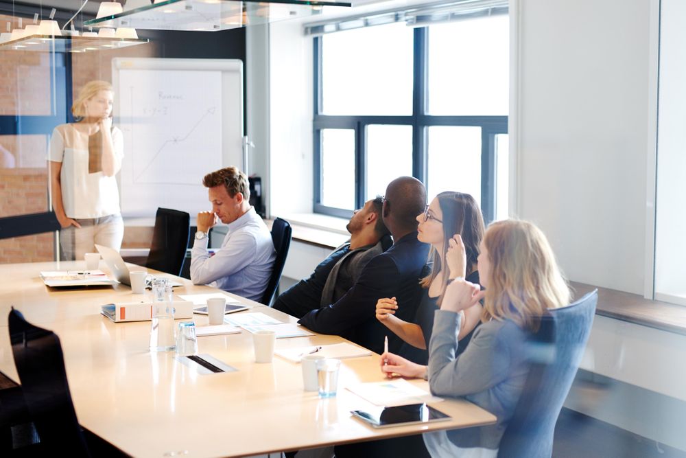 Group of co-workers sitting in boardroom in a meeting