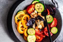 Top view of healthy gourmet salad with tomatoes, cucumber and yellow peppers