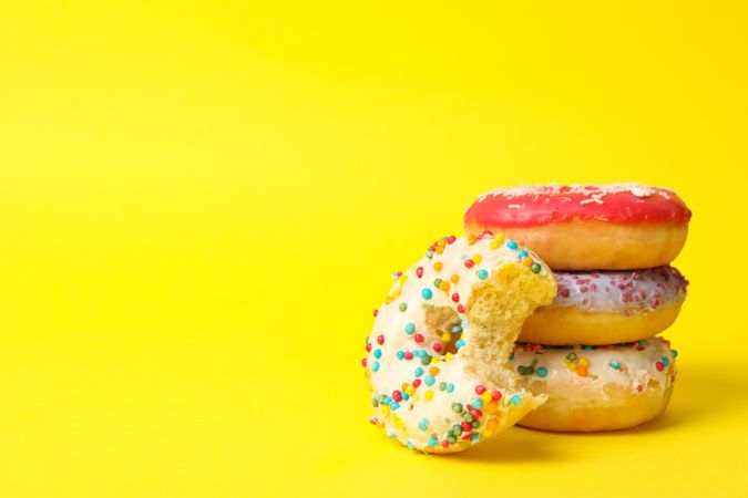 Tasty donuts on yellow background, space for text
