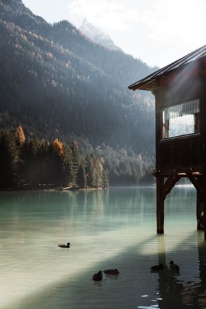 House on stilts on lake near mountains