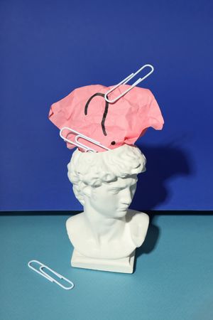 Bust of David with crumpled post it note with question mark and paper clips, vertical