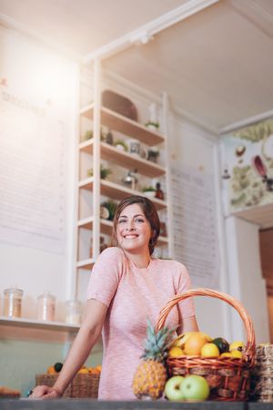 Smiling juice bar owner standing behind the counter
